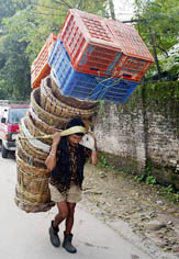 A Nepalese porter begins his day by carrying a big load after curfew was lifted in Kathmandu on Sunday
