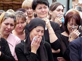 Relatives and neighbours of killed sisters Irina and Alina Toba cry during their funeral in the town of Beslan in the province of North Ossetia near Chechnya on Sunday