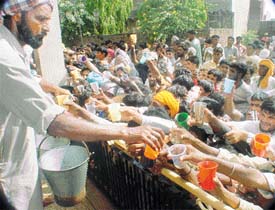 Devotees scramble for liquor prasad at Baba Roodu Shah Dargah, Kounke Kalan