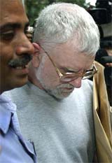 A policeman escorts Allan John Waters, a 56-year-old British citizen, after his appearance in a court on Tuesday. Waters was arrested on Monday in connection with a case of sexual abuse of boys at a shelter in Mumbai. He has not been formally charged with any offence. 