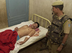 A CRPF jawan looks on at his injured colleague in a hospital in Srinagar on Thursday. A CRPF soldier was killed and three others were wounded in a grenade explosion.
