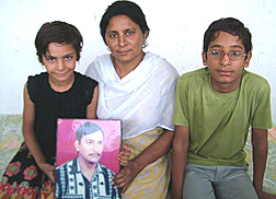 Usha Wadhera along with her children and a picture of her late husband.