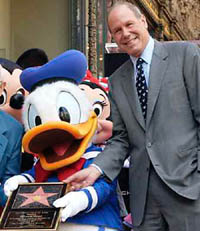 Walt Disney Chief Executive Michael Eisner said on Friday that he would step down from the media conglomerate in 2006 aiming to end his two-decade reign on his own terms after a shareholder revolt nearly cut it short earlier this year. Mr Eisner poses with Disney character Donald Duck in this file photo.