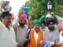 Haryana Chief Minister Om Prakash Chautala, Sukhbir Badal and Abhay Chautala carry containers of sacred water fetched from Sodhra