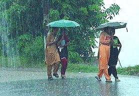 College girls with umbrellas return home from their college in Hamirpur on Wednesday