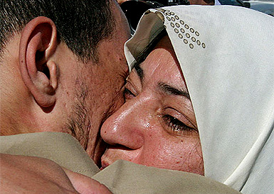 An Iraqi woman cries, as she hugs her husband, a former prisoner, shortly after his release in Amiriya district of Baghdad on Wednesday