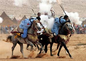 Moroccan nomadic riders fire from their guns during a festival