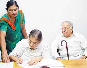 Ms Sneh Lata Dixit and Mr Shankar Dixit sign the possession letter of a plot allotted to Madhuri Dixit at HUDA Complex in Panchkula