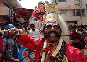 A folk artist perform during a Ganeshotsav procession