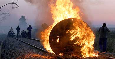 Izar shipyard workers put barricades on the rails