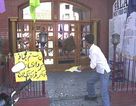 An activist of the Jammu and Kashmir Democratic Liberation Party attempts to break the windows