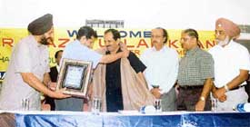 Deputy Commissioner Anurag Verma presents a shawl to Rai Azizullah Khan, MP, Pakistan, during a function held at Ludhiana