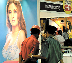Security guards engrossed in an advertisement on display at Aarogya Mela 2004