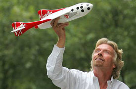 British billionaire Sir Richard Branson holds a scale model of a spacecraft at a news conference in London