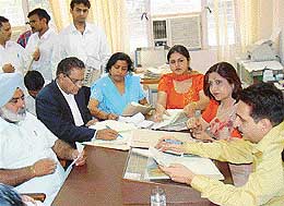Mr Sant Parkash, Judge of the Permanent Lok Adalat, (extreme right), settles cases at a special Lok Adalat in Chandigarh on Monday. 