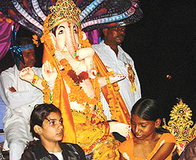 Devotees chant as they carry a large clay idol of Lord Ganesh for immersion