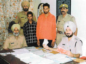 DSP Harjit Singh Brar shows air tickets and other incriminating documents recovered from Kulbir Singh Dhillon (in red shirt) after his arrest at Jagraon.