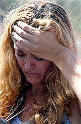 A woman grieves at the scene where Palestinian gunmen killed an Israeli woman taking a morning jog near Jewish settlements in north Gaza on Thursday