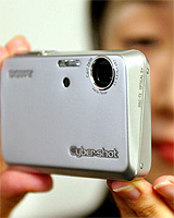 Japanese electronics giant Sony employee Saori Yakahashi displays the new thin digital camera, Cybershot DSC-T3 