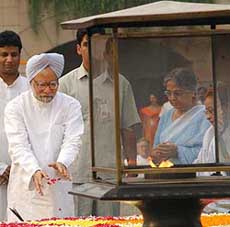 Prime Minister Manmohan Singh and his wife pay homage at the samadhi of Mahatma Gandhi on his 135th birth anniversary at Rajghat in New Delhi on Saturday. 