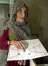 An Afghan refugee woman holds her voter registration papers at a registration centre in Quetta 