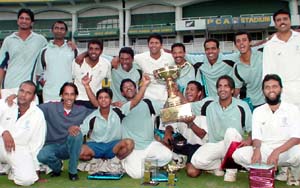 The jubilant Canara Bank players pose with the trophy after defeating Bengal in the final of the All-India JP Atray cricket tournament 