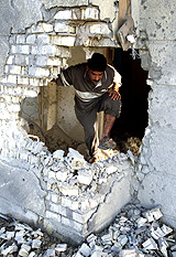 An Iraqi walks through a damaged building after an overnight air strike in Falluja