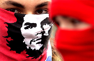 A member of Red Youth Vanguard leftist political party with his face wrapped in a bandana sporting a portrait of Ernesto Che Guevara