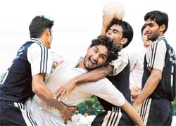 Dalbara Singh of Panjab University being checked by Delhi University players during a semifinal match of All-India Inter-university Handball Championship at Panjab University on Monday. 