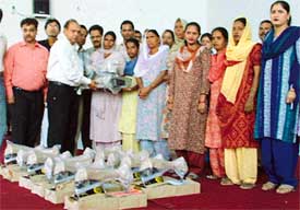 NSS volunteers of Kamla Lohtia Sanatan Dharam College distribute sewing machines among needy and poor women