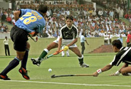Indias Tushar Khandekar hits the ball as Pakistan players Zeeshan Ashraf and Tariq Aziz try to intercept