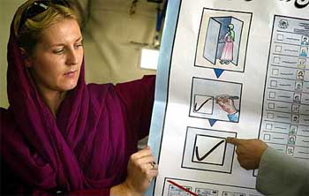 A UN official explains to a student in Kabul on Tuesday the proper procedure to vote. The Free and Fair Elections Foundation of Afghanistan says it expects a large turnout for the first Presidential election. 