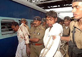 Two dacoits being taken away by the Railway Police after they looted passengers of the Howarah-Jammu-Tawi Himgiri Express near the Hathidah railway station on Wednesday. 
