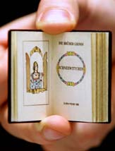 An employee of Russian publishing house Terra displays the world's smallest edition of the famous 'Snowhite' fairy tale of the German writers, the Grimm Brothers, during the opening day of the book fair in Frankfurt 