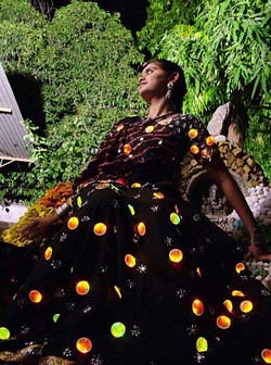 A woman displays a 'Chaniya Choli' dress made with light bulbs, which she will wear for the Navratri festival in Ahmedabad