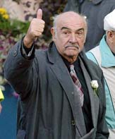 Actor Sean Connery gestures to the crowd after arriving for a ceremony to mark the official opening of the new Scottish Parliament building at Holyrood