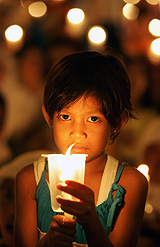 A Indonesian young girl holds a candle during a rally protesting the recent eviction of the city's slum dwellers by the government