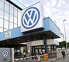 A man walks past the entrance of the Volkswagen plant in Brussels on Tuesday. Germany is likely to be hauled to court on Wednesday by the European Commission over a law that shields carmaker Volkswagen AG from hostile takeovers, a climax in the EU executive's campaign to boost cross-border investment. 
