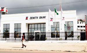 A woman walks past a closed bank in a Lagos street in south-west Nigeria on Tuesday. World oil prices stormed above $ 54 for the first time today as strikes in Nigeria and Norway raised worries about possible supply shortages during the northern hemisphere winter. The price of reference light sweet crude for delivery in November rose 64 cents to $ 54.28 a barrel in electronic trading on the New York Mercantile Exchange, the highest in the contract's 21-year history.
