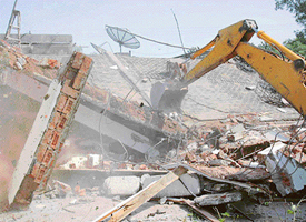 A JCB razes unauthorised construction at the Bhinder Farms in Chandigarh on Tuesdday. 