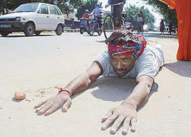 A devotee crawls to the Mansa Devi shrine on the first day of Navratras, in Panchkula, on Thursday.