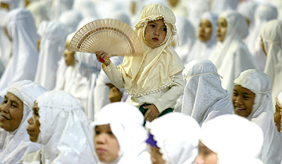 A child stands during a prayer at the Istiqlal mosque