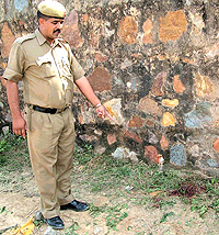 A policeman shows the spot where dreaded criminal Suleman was shot at Aaya Nagar near Mehrauli in the Capital on Friday