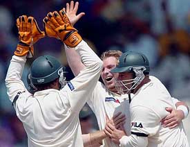 Australian spinner Shane Warne being congratulated by his skipper Gilchrist and Darren Lehmann after he broke the world record