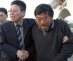 An unidentified Chinese embassy official escorts freed Chinese engineer Wang Ende