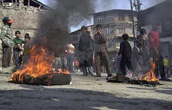 Kashmiri boys stand near the buring tyres during a demonstration in the downtown area of Srinagar on Sunday. Residents were protesting against the arrest of a Kashmiri youth. 