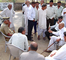 Dharam Singh, who had headed the khap panchayat on the Sonia issue, and others summoned by the National Commission for Women wait for the commission team at Asanda village on Monday