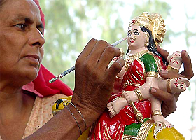 An artist gives final touches to an idol of Goddess Durga at a roadside workshop in Ambala on Monday