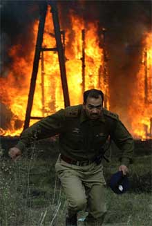 A police officer runs in front of a burning transformer