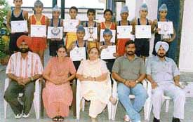 The hockey team of Guru Nanak Model Senior Secondary school with the Principal, Ms Urmil Sood, and staff